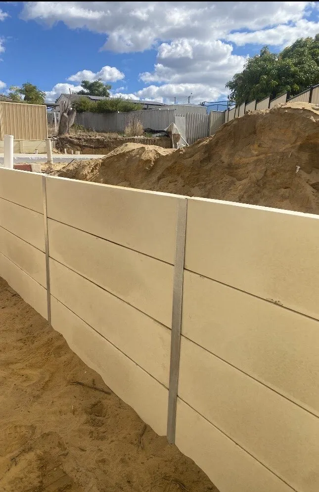New panel retaining wall with fresh sand backfill on a Perth building site