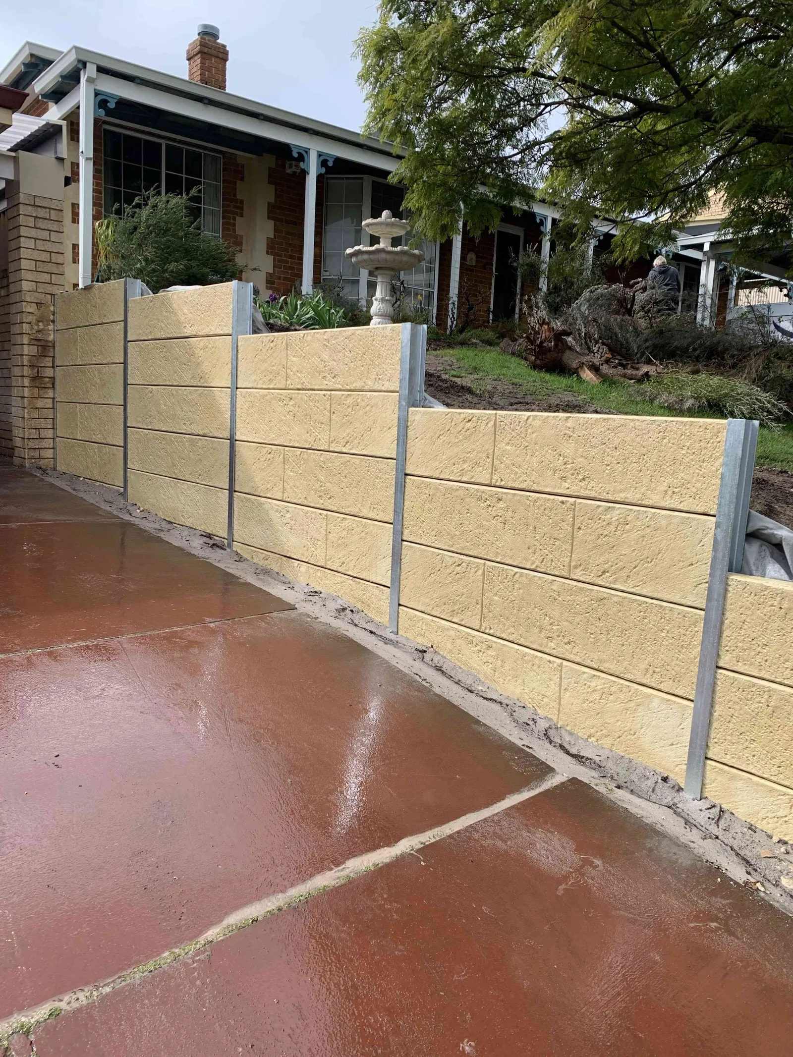 Stepped panel retaining wall following the slope beside a Perth driveway